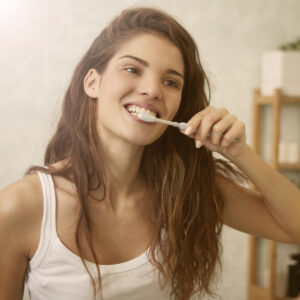 St. Charles, IL Woman cleaning her teeth with a tooth brush.