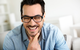 man showing off his restored smile after visit to Elgin, IL oral surgeon
