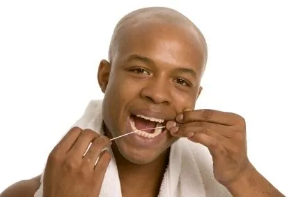 A man flossing to prevent gum disease, a common cause of bad breath.